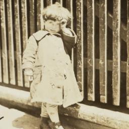 Child Beside a Wooden Fence